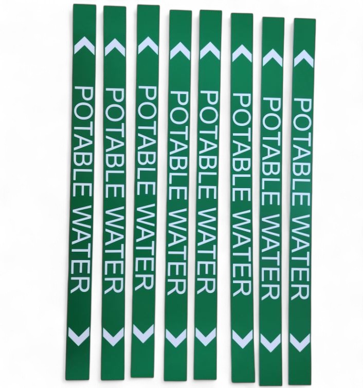 Green acrylic pipe markers labelled ‘Potable Water’ with white directional arrows, designed for identifying drinking water pipelines in industrial and commercial plumbing systems