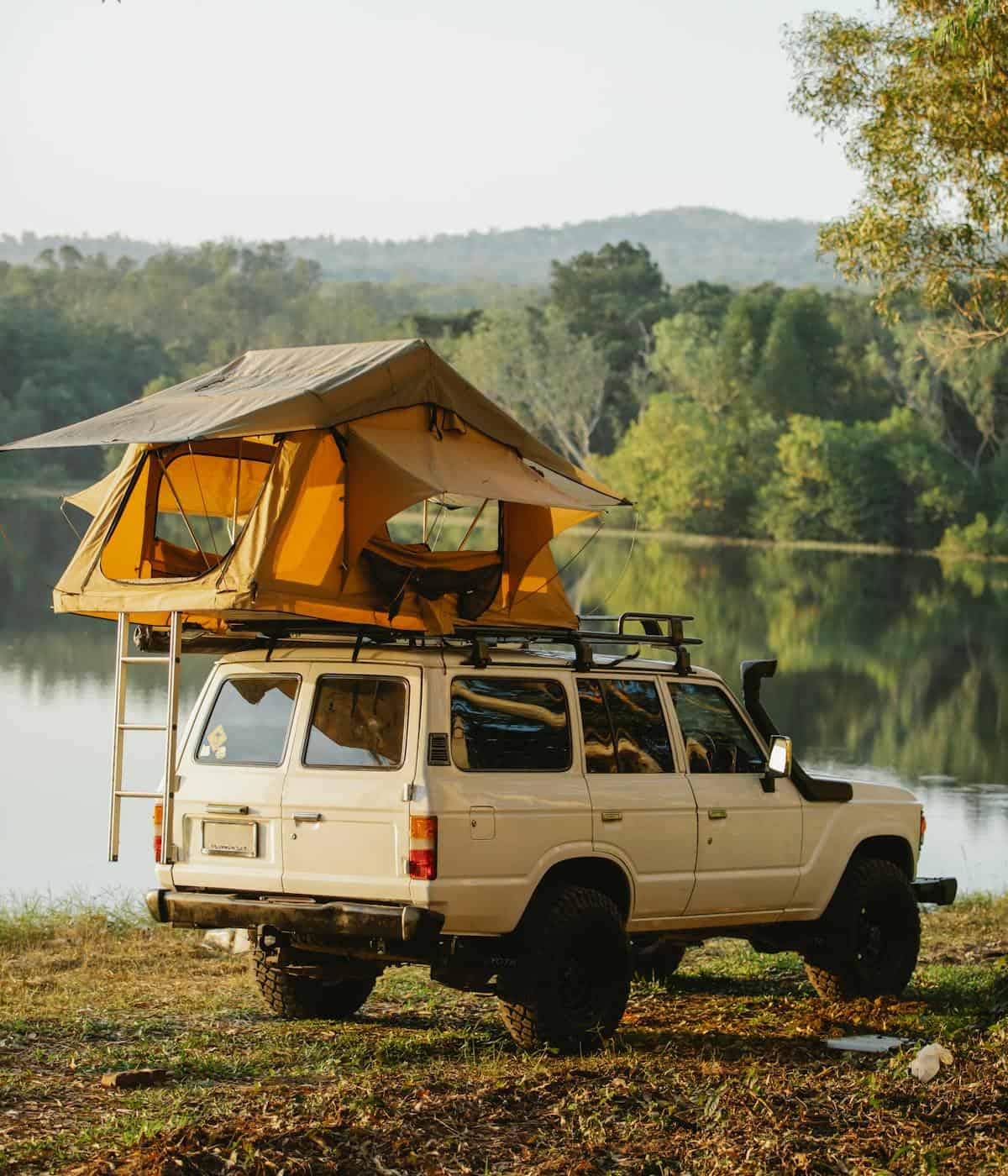old tan 4x4 with roof tent lake camping landscape seikk magazine app lifestyle magazine photo unsplash