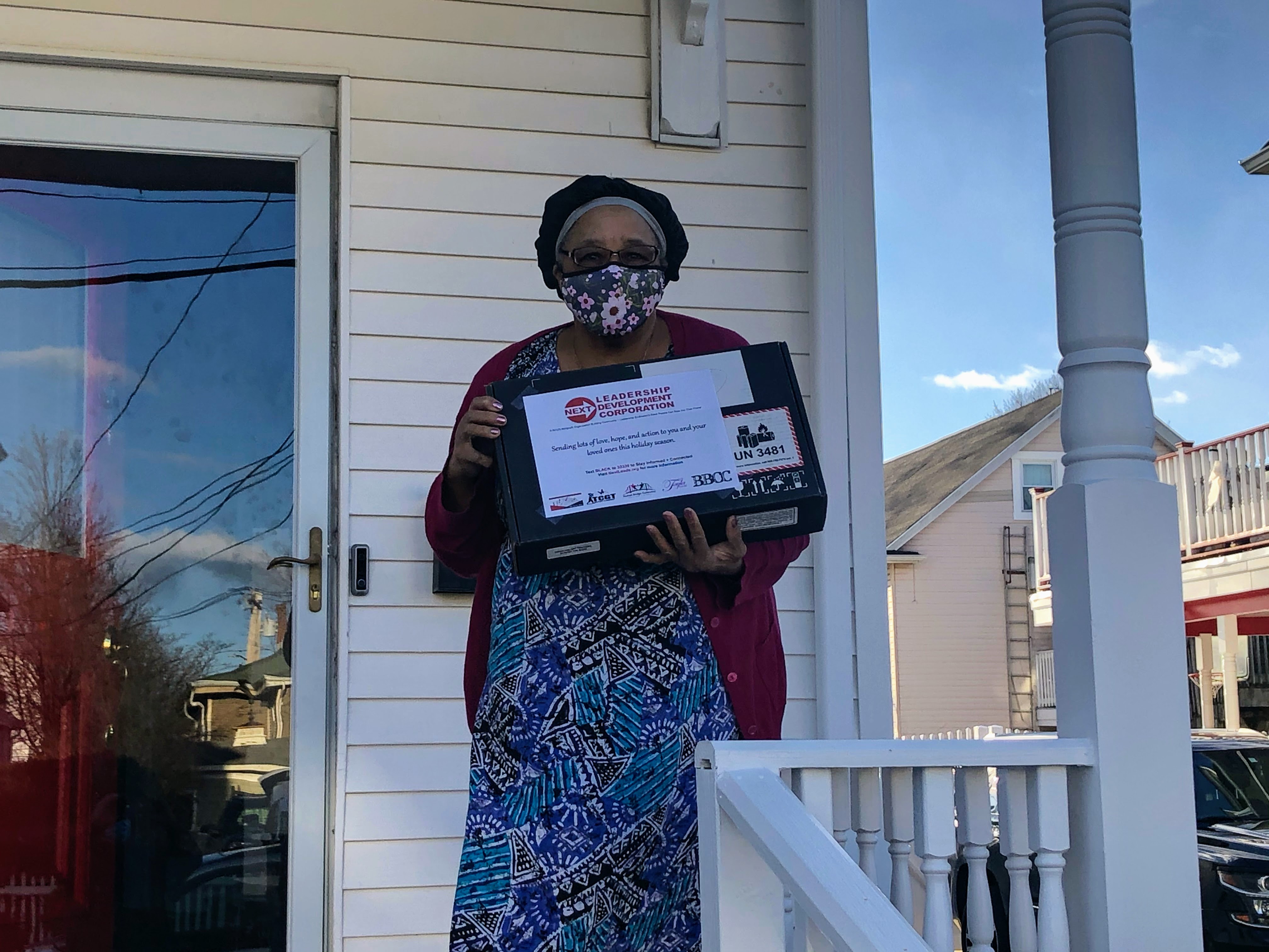 Elder holding a laptop she received from Next Leadership Development to stay connected to family during COVID-19 pandemic