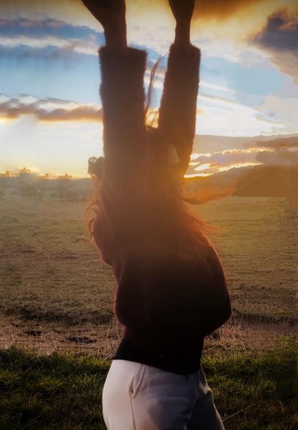 Silhouette of Deva Tara in a movement pose at sunset