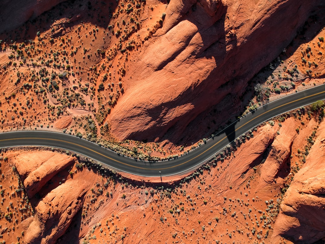 Aerial view of a winding road through red rock formations and desert vegetation. Bath Digital Marketing Agency