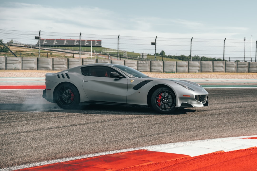 A grey Ferrari drifting on a racetrack, with smoke coming from its rear tires Bath Digital Marketing Agency