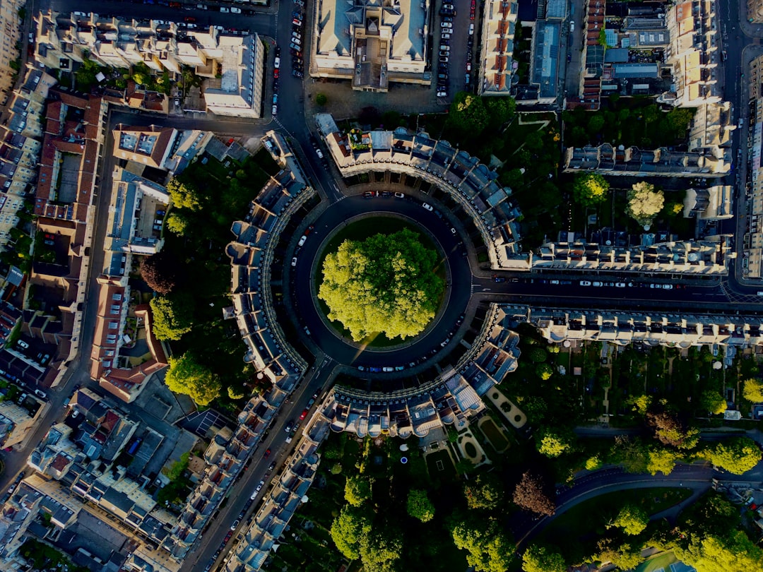 Aerial view of a circular green park surrounded by a road and residential buildings, showcasing the layout and greenery in an urban setting. Bath Digital Marketing Agency