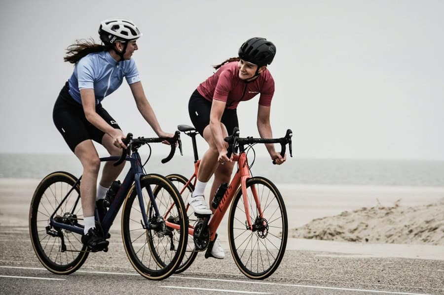 Two women cyclists on a scenic bike ride, showcasing social media adventure and engagement for brand promotion. Bath Digital Marketing Agency