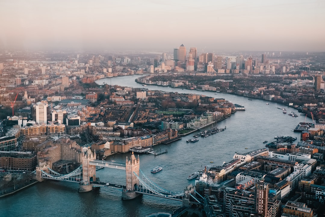 Aerial view of London featuring the River Thames, Tower Bridge in the foreground, and the city skyline in the background during sunset. Bath Digital Marketing Agency