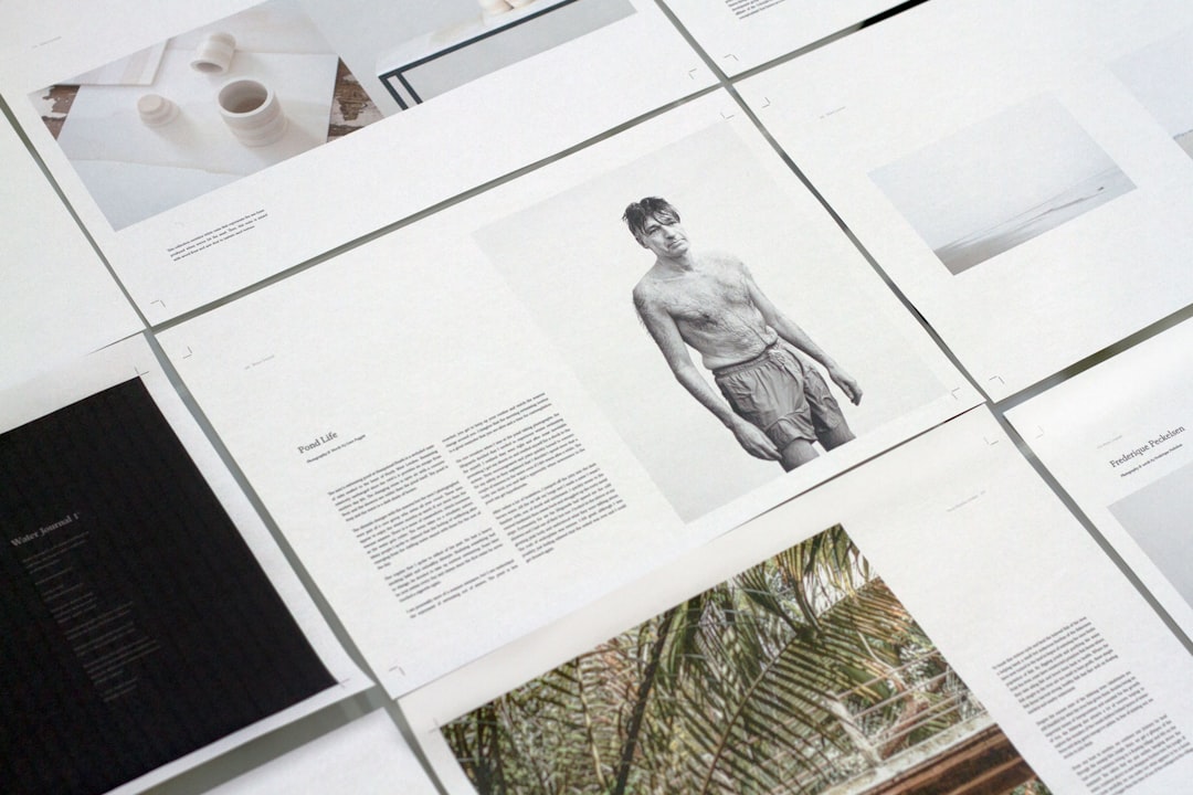 A flat lay of printed design layouts featuring photographs and text, including a black and white image of a shirtless man and various artistic elements. Bath Digital Marketing Agency
