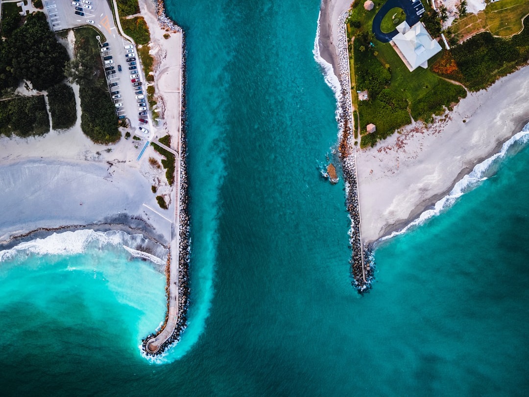 Aerial view of a coastal inlet with turquoise waters and rocky jetties extending into the sea– Bath Digital Marketing Agency