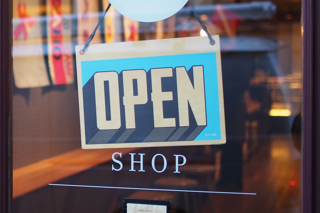 A brightly coloured "OPEN" sign hanging in a shop window, indicating that the store is welcoming customers. Bath Digital Marketing Agency