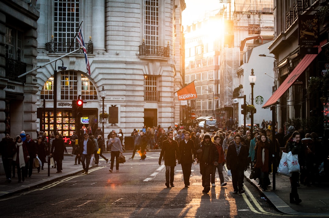 Busy urban street scene with pedestrians crossing and sunlight streaming between buildings. Bath Digital Marketing Agency