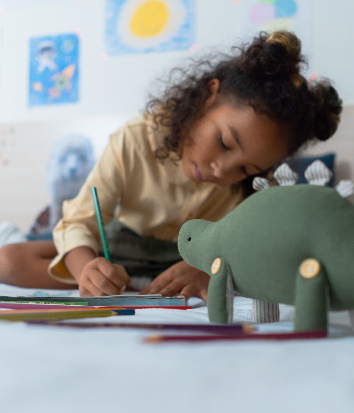 A girl working on her coloring book at home on the floor, enjoying a personalized homeschooling curriculum. This moment reflects the flexibility and creativity fostered by online homeschooling programs and homeschool coaching services.