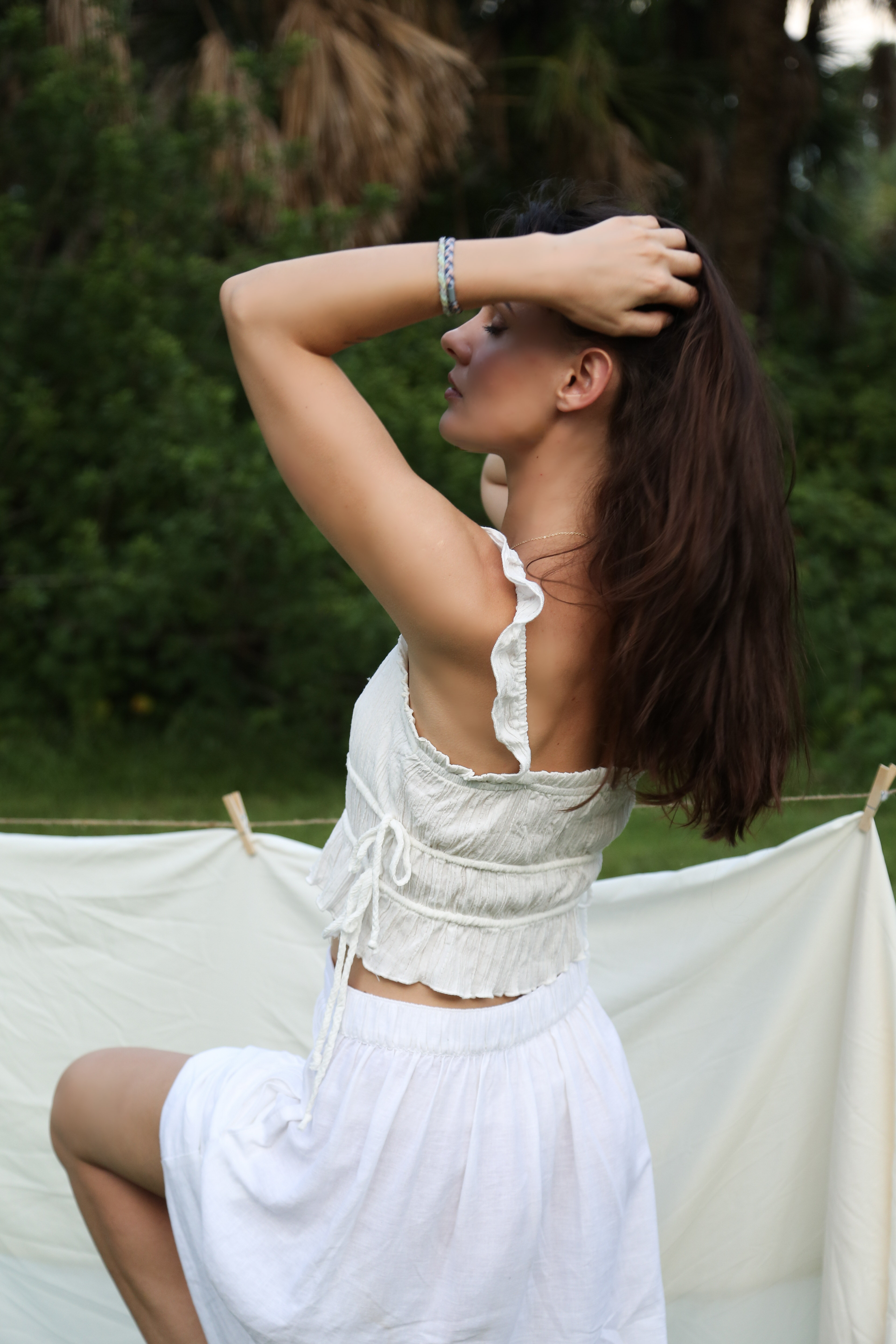 Tall slender porcelain bottle with natural clay textured body and cork stopper.