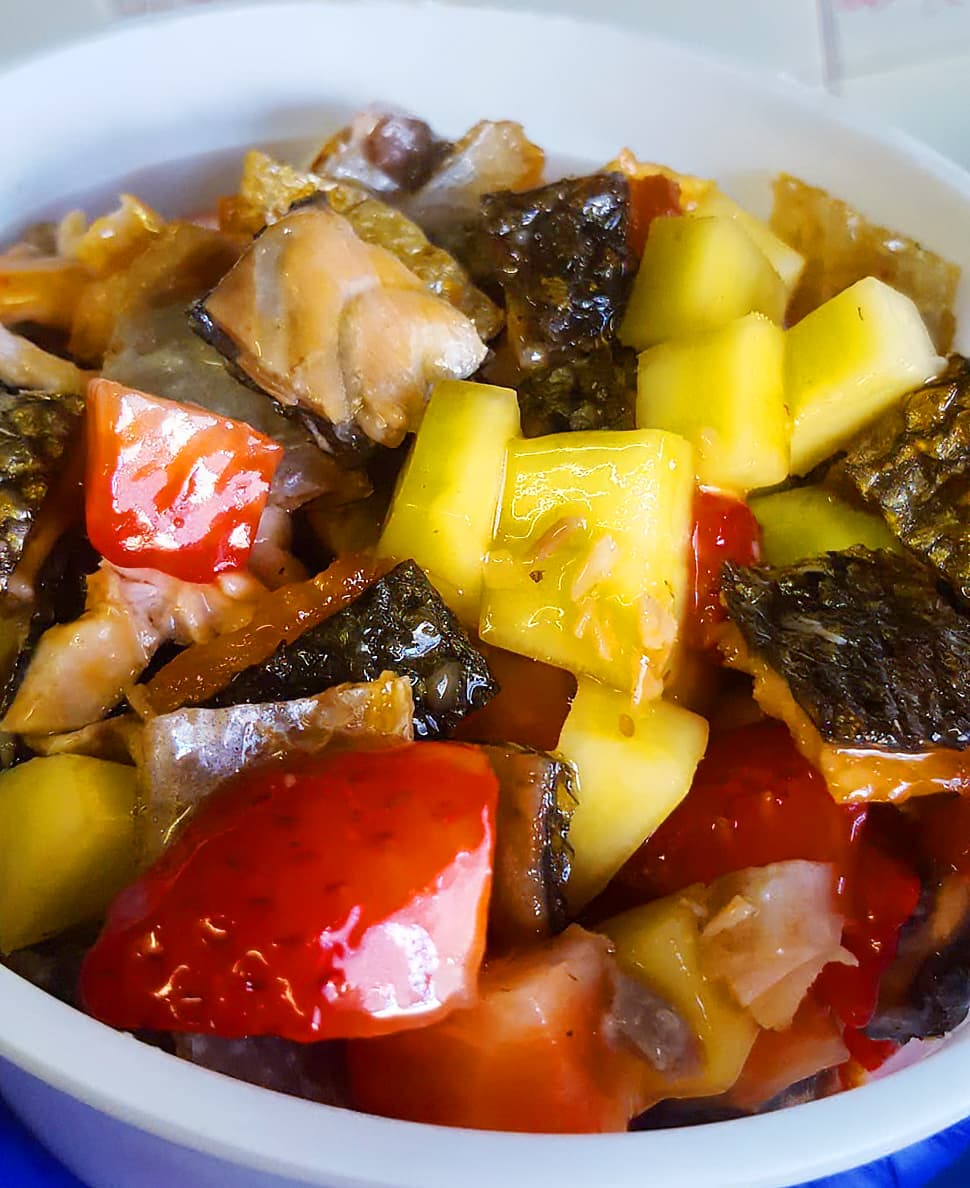 Wood table with porcelain mug, leather journal, brass pen, leather key ring, and a houseplant.