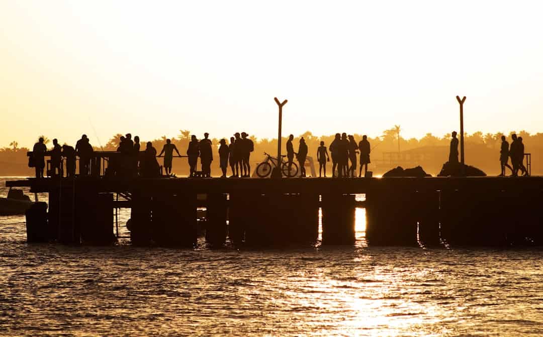 Pier at sunset in Santa Maria Cabo Verde with fisherman and african children - Where is Cape Verde, Map, Guide and Tips -  Photo by Álvaro Ibáñez | Cape Verde African Caribbean