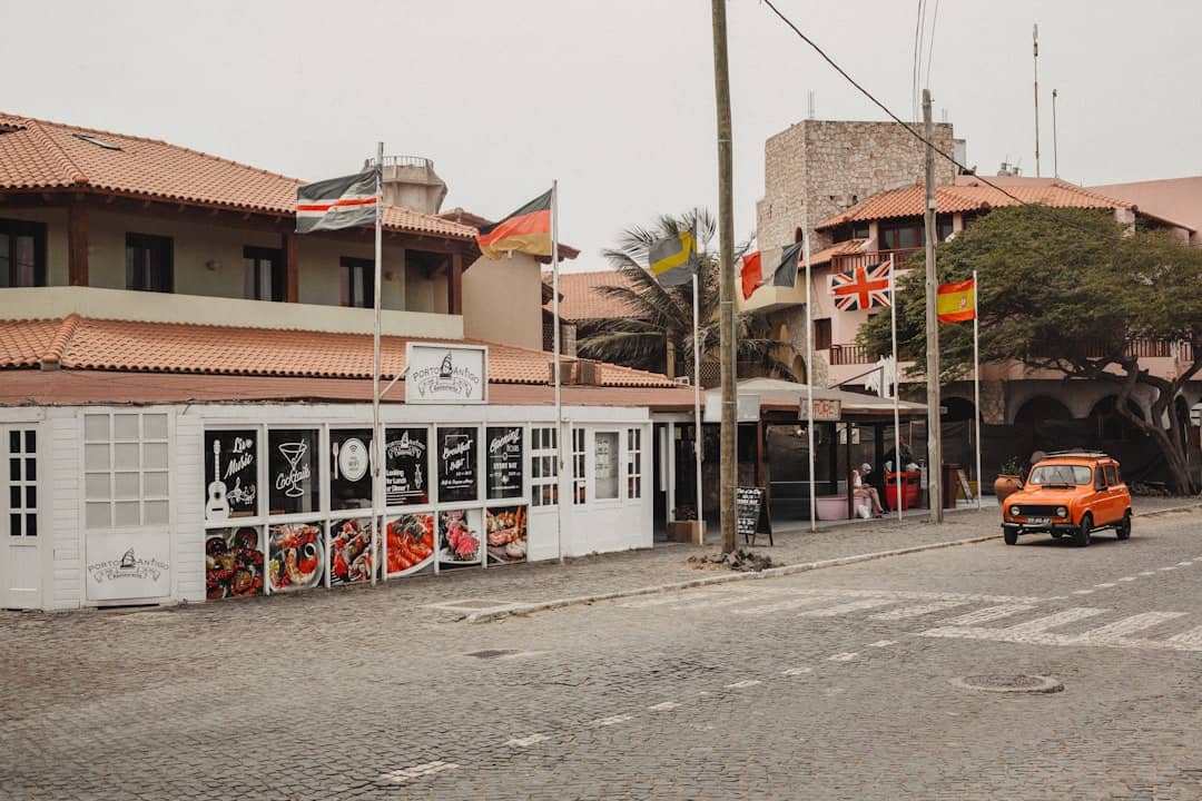 Bar with flags and car in Santa Maria Town on Sal Cabo Verde – best time to visit Cape Verde on Holiday - Photo by NIYI OKEOWO | Cape Verde African Caribbean