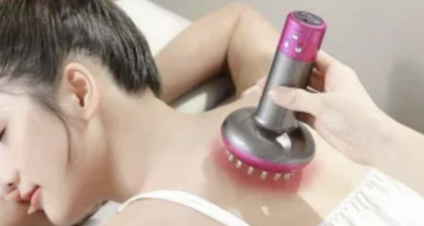 A woman receiving thermal therapy at ViyUla Beauty Spa in Darwin, with a heated massage device applied to her upper back to stimulate collagen and relieve stress.