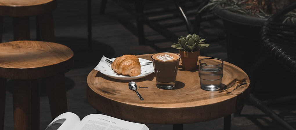 beann artisan coffee shop table with a latte, croissant, and glass of water - beann speciality coffee
