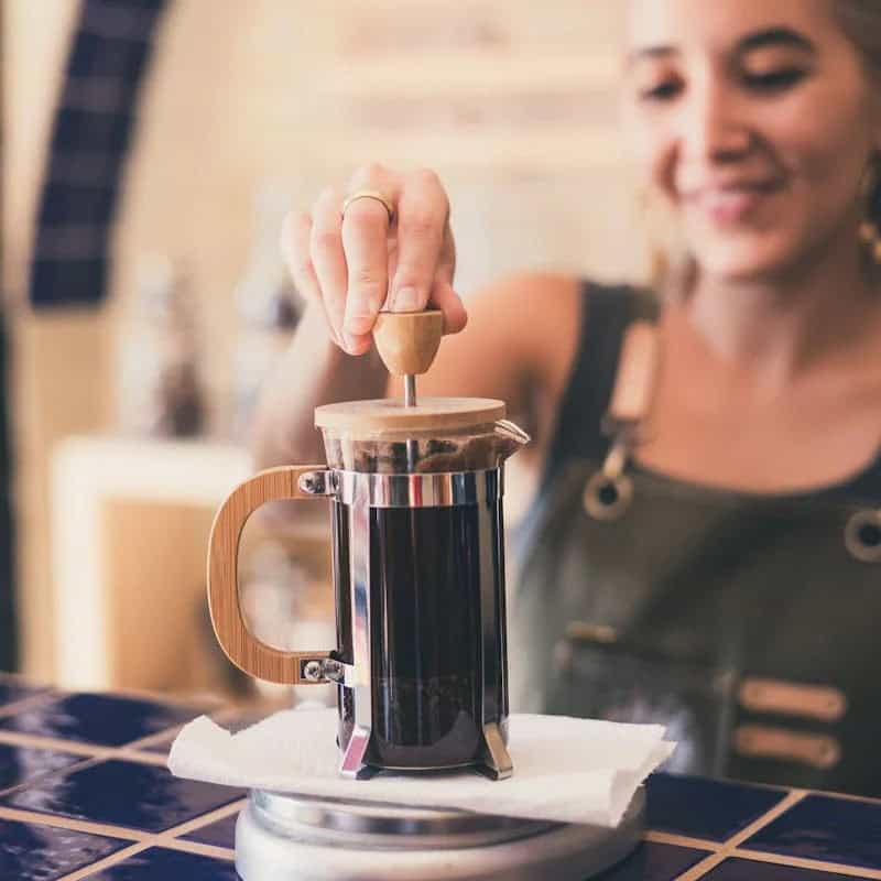 A barista using a bamboo French press to make coffee for Beann Artisan Coffee - beann speciality coffee