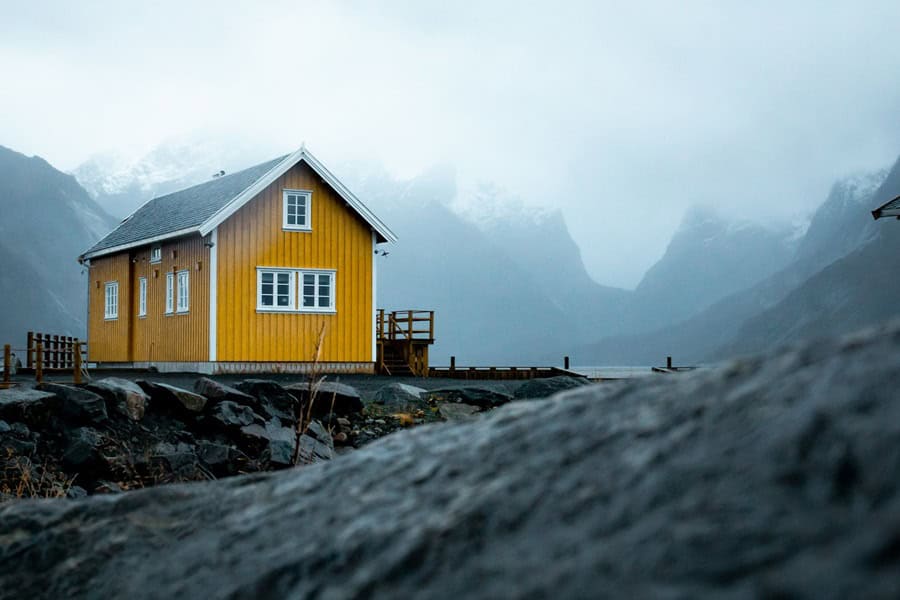 Yellow lake cabin with mountains- Top Digital Product Consultancy Contact - photo unsplash | de Paula Consultants