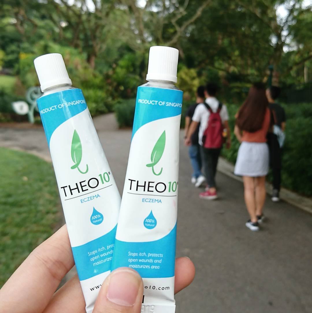 Desk with leather desk pad, walnut desk organizer, wireless keyboard and mouse, and porcelain mug.