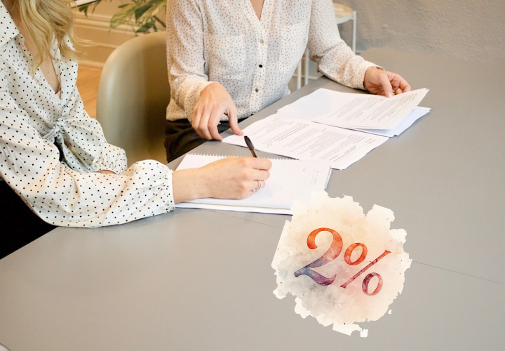 Desk with leather desk pad, walnut desk organizer, wireless keyboard and mouse, and porcelain mug.
