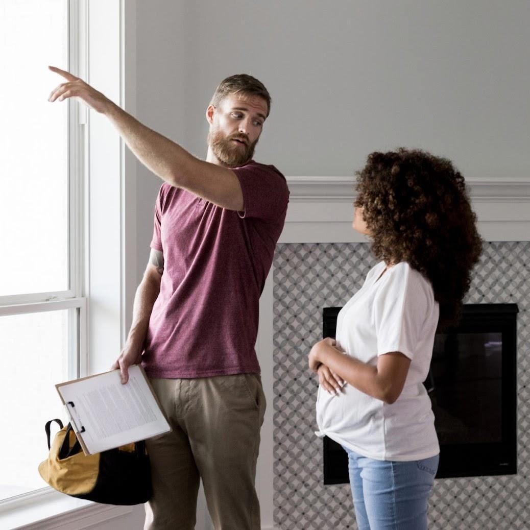A contractor explaining costs to a young pregnant woman