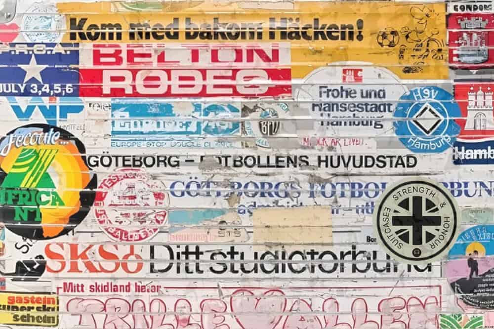 Close-up of a silver vintage aluminium suitcase adorned with colourful travel stickers, evoking a sense of adventure and nostalgia