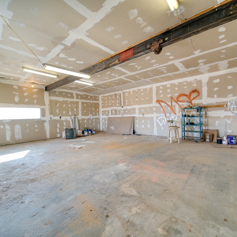 An empty garage featuring high ceilings and bare walls, showcasing a spacious and uncluttered environment.