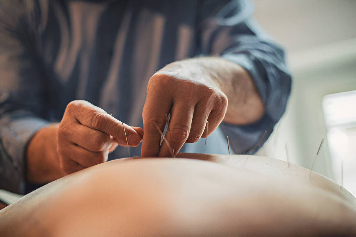 Hand holding black machined steel mechanical pencil with brass tip and top.