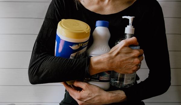 woman holding cleaning supplies