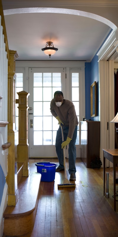 man sweeping the wooden floor
