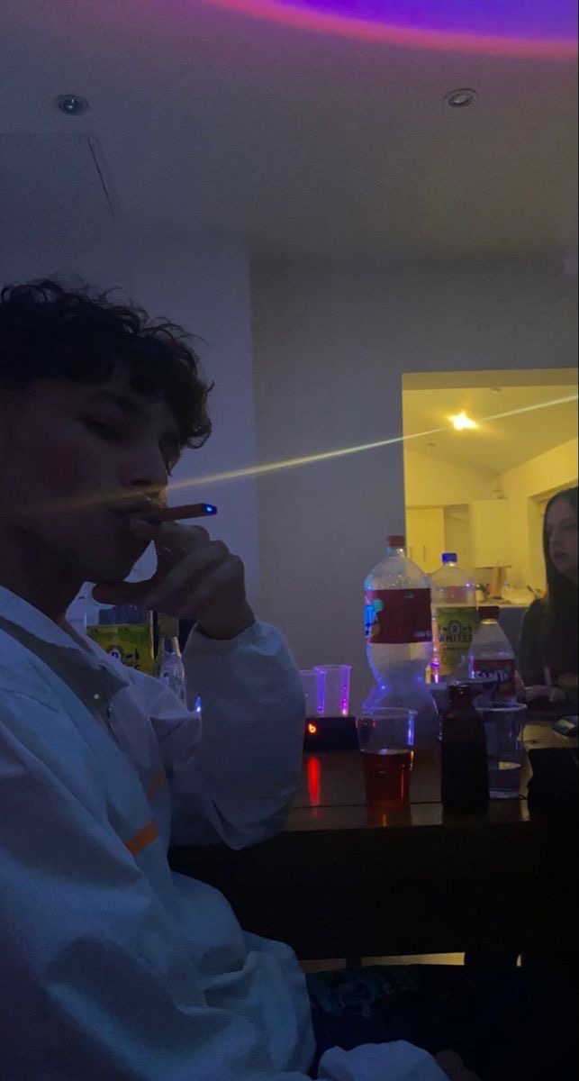Personne dans une ambiance tamisée, buvant avec une paille lors d'une soirée conviviale