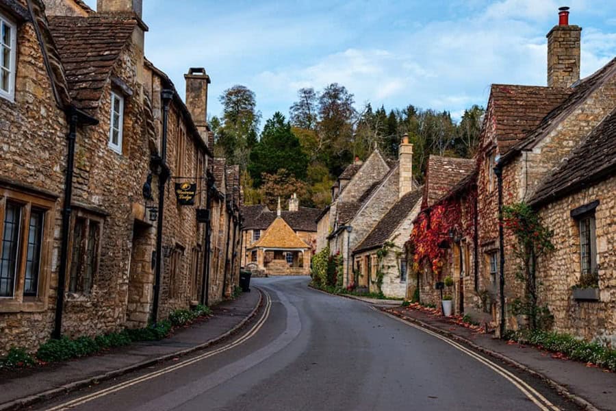 View up the high street to the market cross in Castle Combe Village in the Cotswolds, Wiltshire, UK - Photo by George Ciobra  Castle Combe England