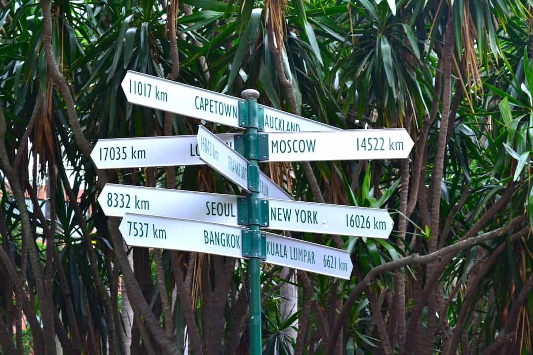 Sign post with world capital cities – How to get to Castle Combe - Photo by Terra Raponi | Castle Combe England