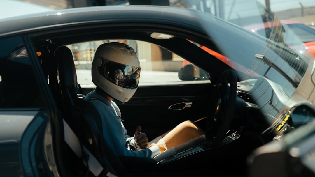 Driver with helmet in a car on a track day - Castle Combe Race Circuit, North Wiltshire, UK – Photo by Marc Kleen | Castle Combe England