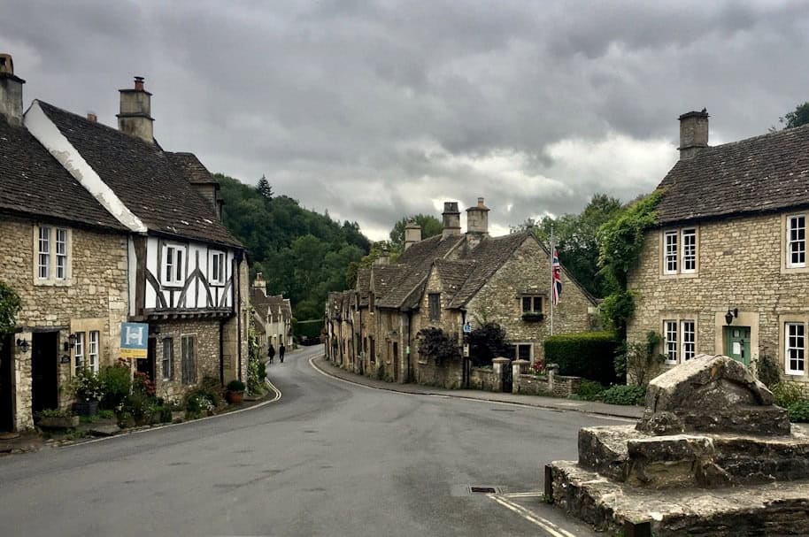 View of the high street Cotswolds cottages in Castle Combe Village, North Wiltshire, UK – How to get to Castle Combe - Photo by Olivier Collet | Castle Combe England