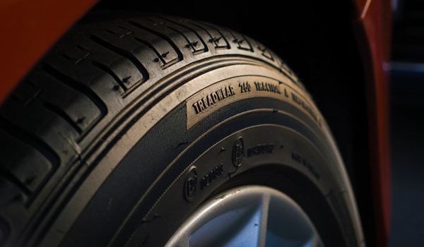 A close-up view of a car tire showcasing its tread pattern and rubber texture.
