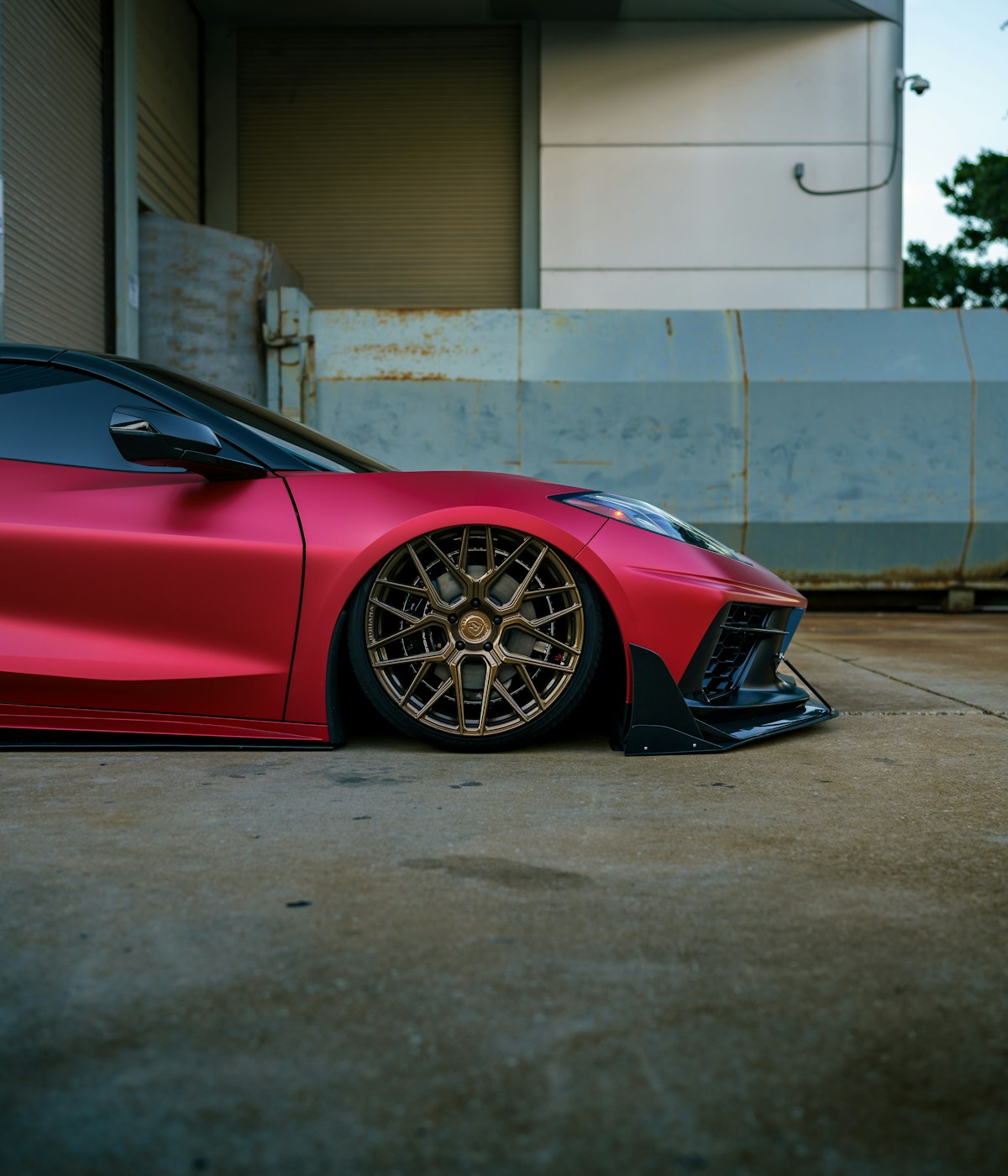 A sleek red sports car showcasing its stylish wheels, emphasizing speed and performance.