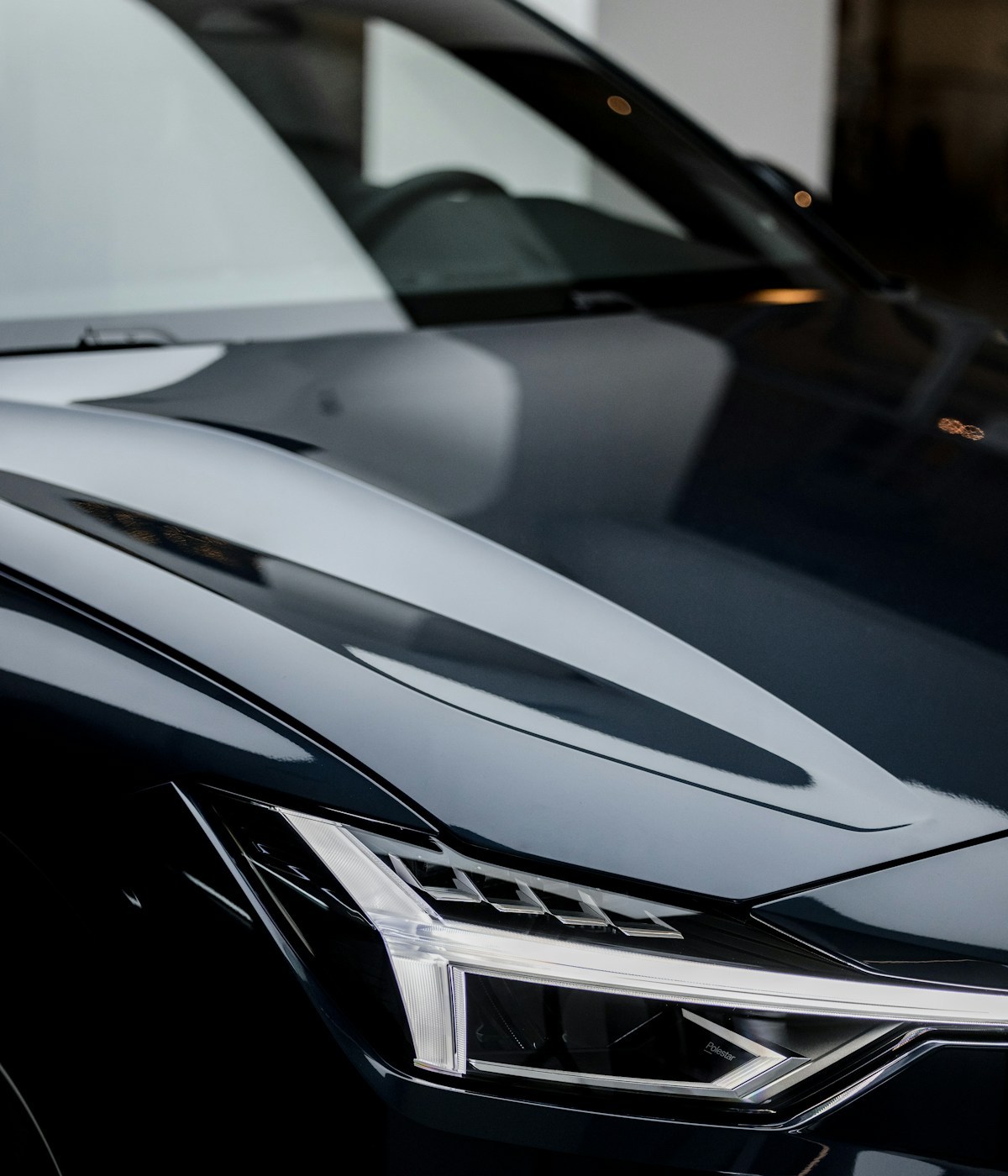 A sleek black Audi car showcasing its front end, highlighting the distinctive grille and elegant design features.