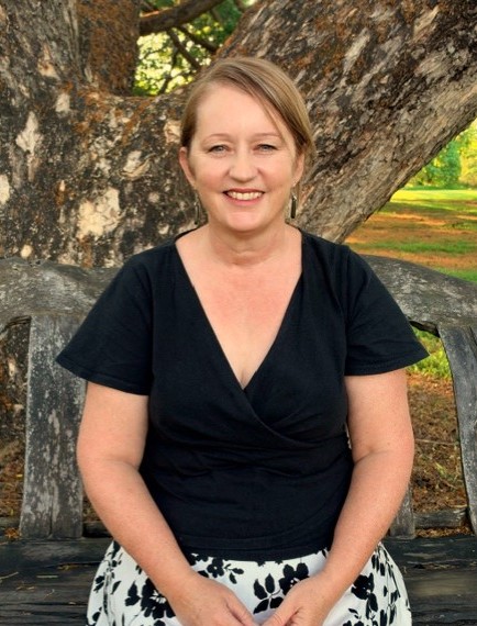 Sharon, counsellor and psychosexual therapist at Willow Connection, seated outdoors in dappled natural light