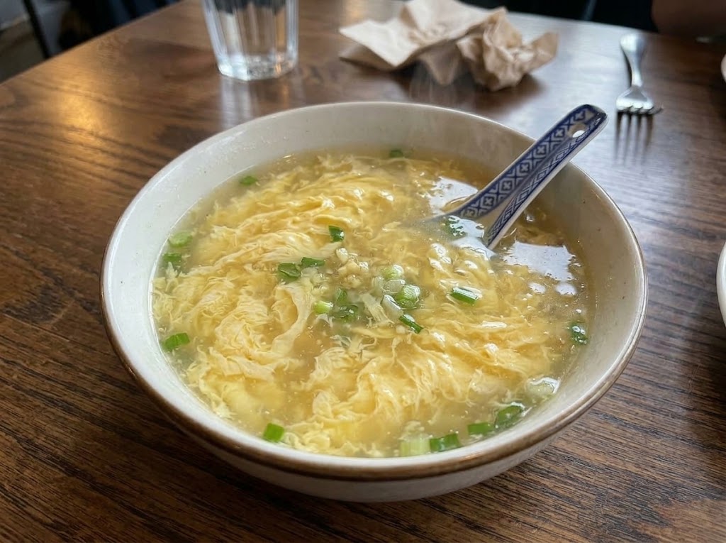 Bowl of egg drop soup with silky egg ribbons and green onions
