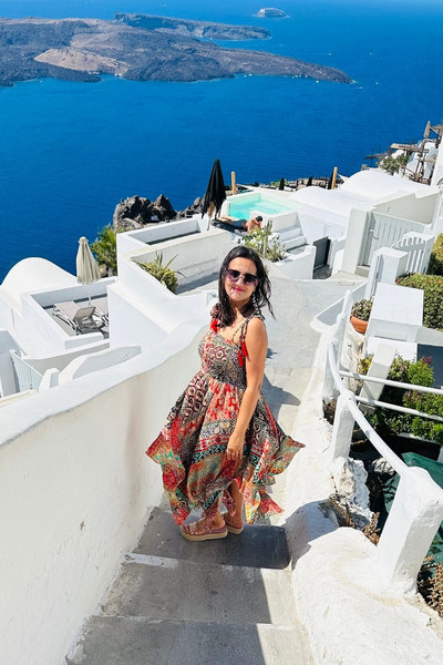 Meghna Patel on white stairs overlooking the caldera