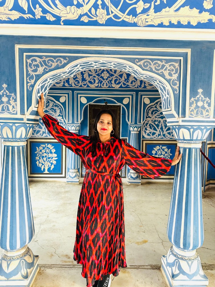 Meghna Patel between blue columns at Jaipur