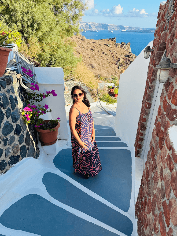 Meghna Patel descending blue-painted steps in Santorini