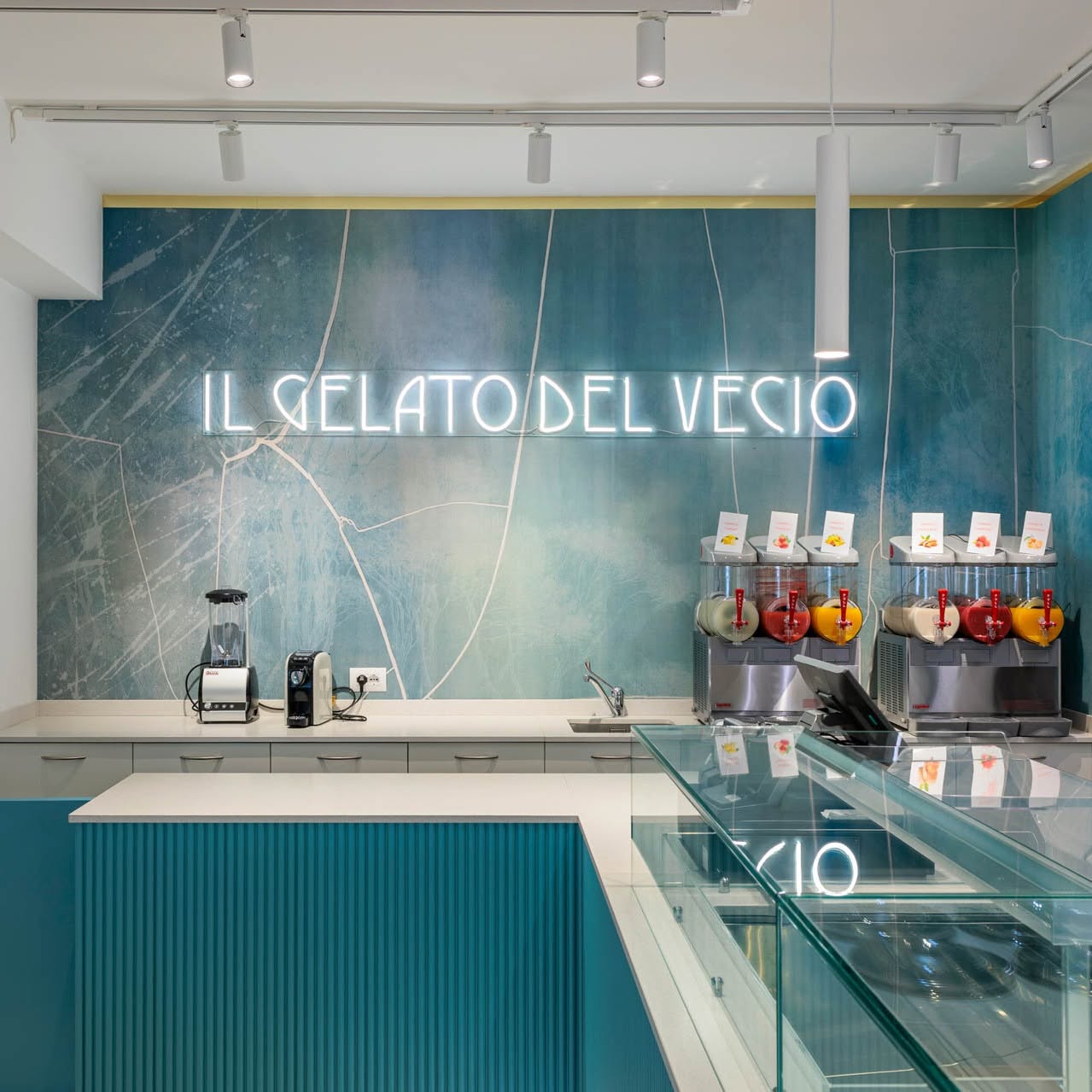 L'interno de Il Gelato del Vecio con l'insegna luminosa e i macchinari