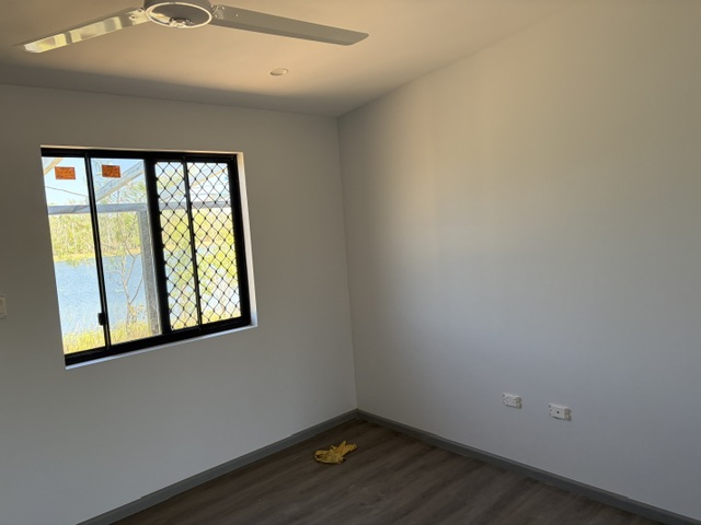 Finished bedroom with ceiling fan and window inside transportable accommodation built in Darwin