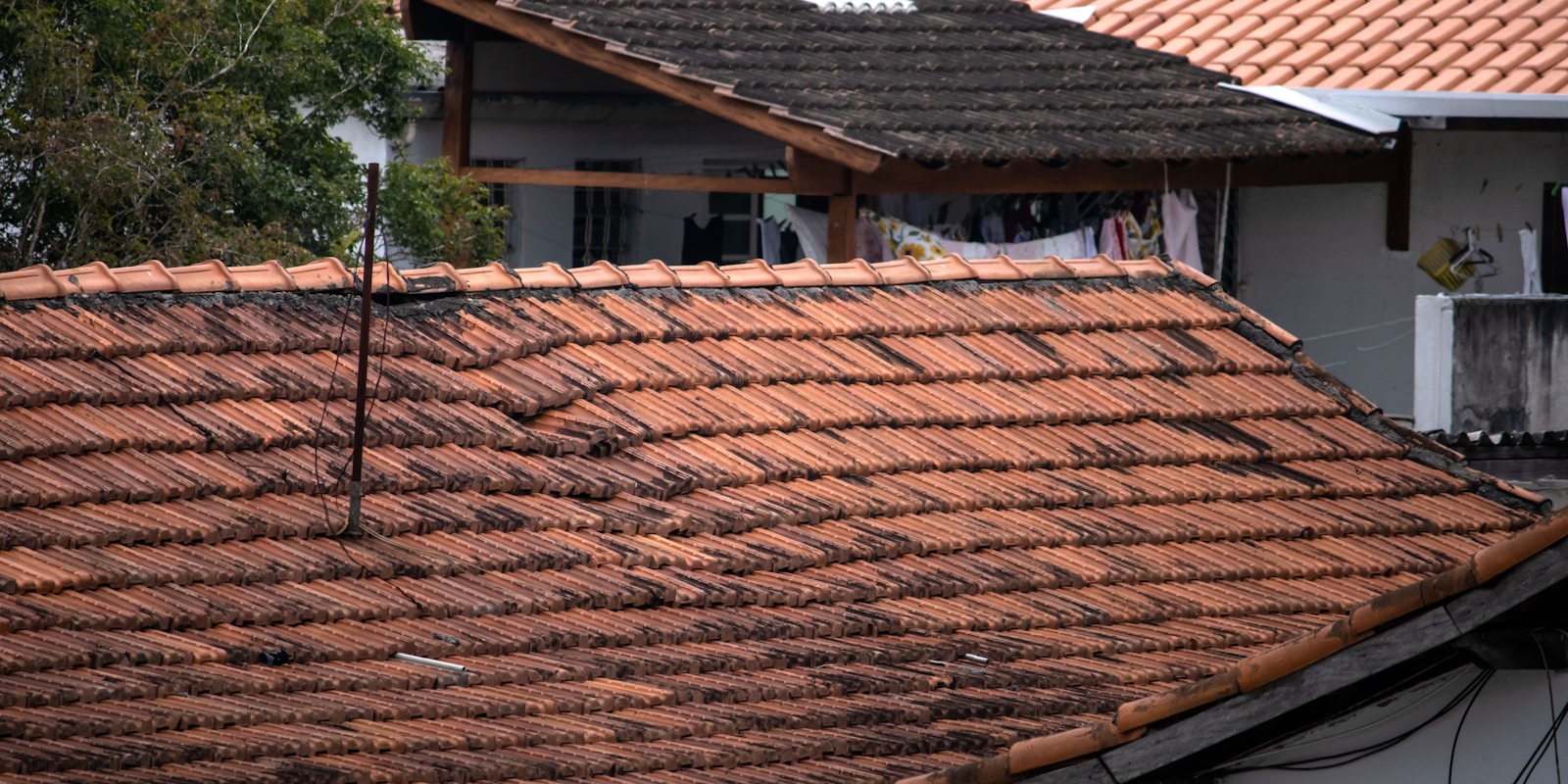 A white house with a tiled roof, showcasing a classic architectural style against a clear blue sky.