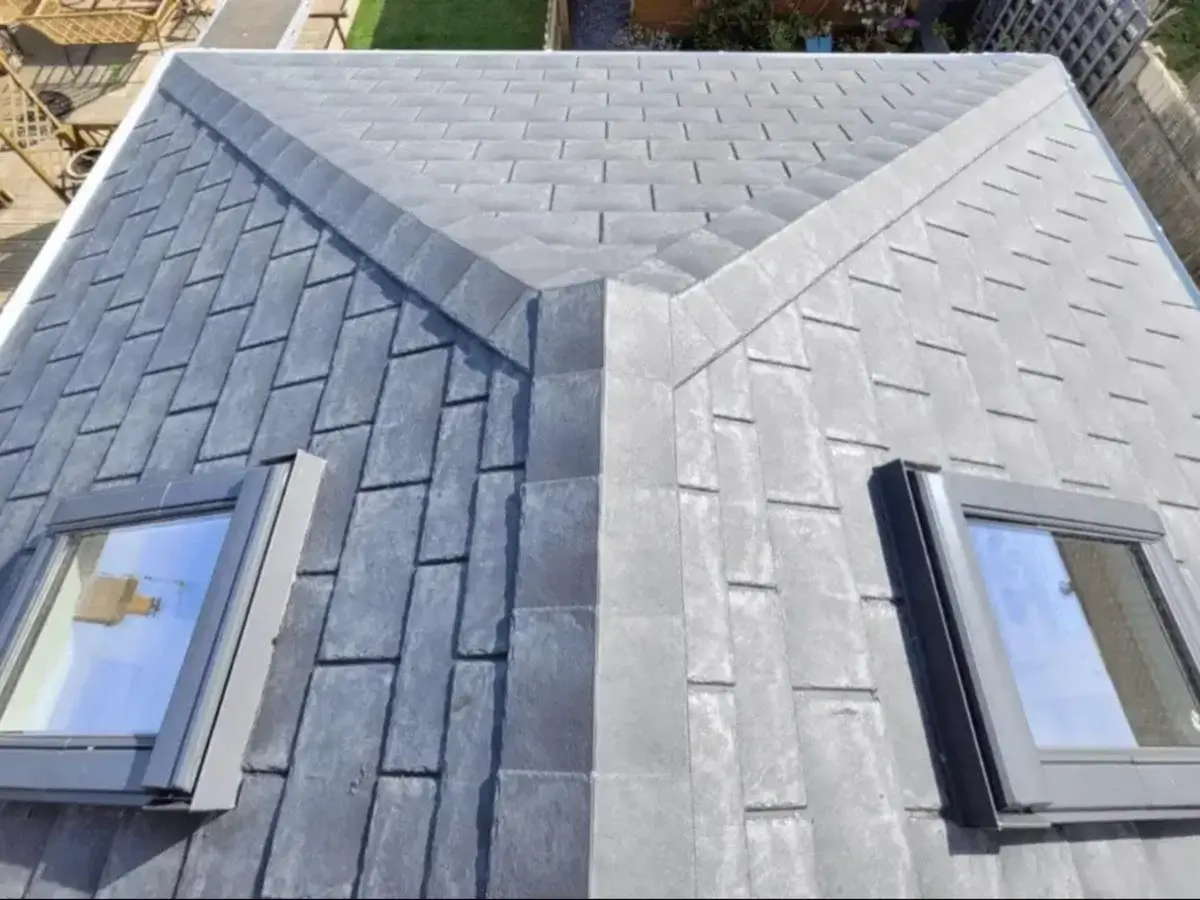 Overhead view of a multi-pitched conservatory roof conversion featuring slate grey lightweight shingles and twin Velux roof windows by Norfolk Exterior Solutions.