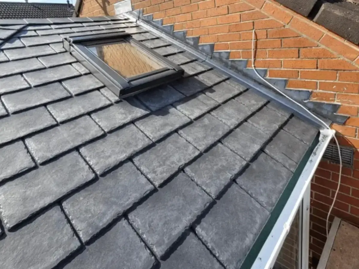 Aerial view of a modern hip-style conservatory roof converted with dark grey lightweight tiles and white trim. Work by Norfolk Exterior Solutions.