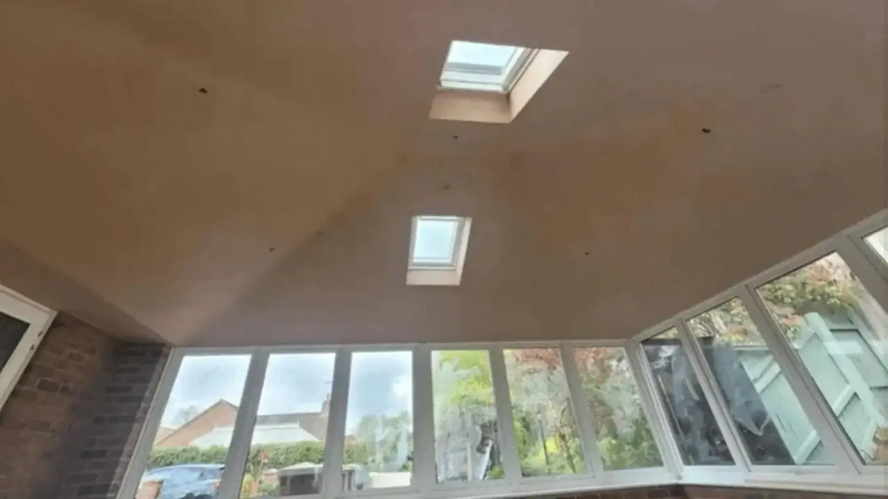 Interior view of a freshly plastered vaulted conservatory ceiling with integrated energy-efficient roof windows. Completed by Norfolk Exterior Solutions.