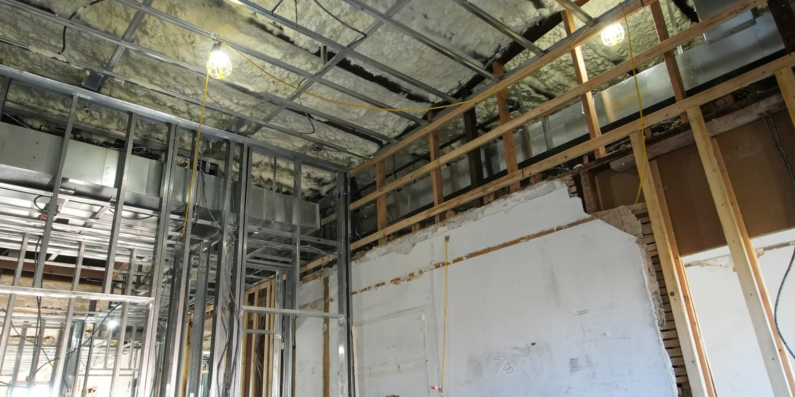 A construction site inside a room, featuring tools, materials, and workers engaged in various tasks.